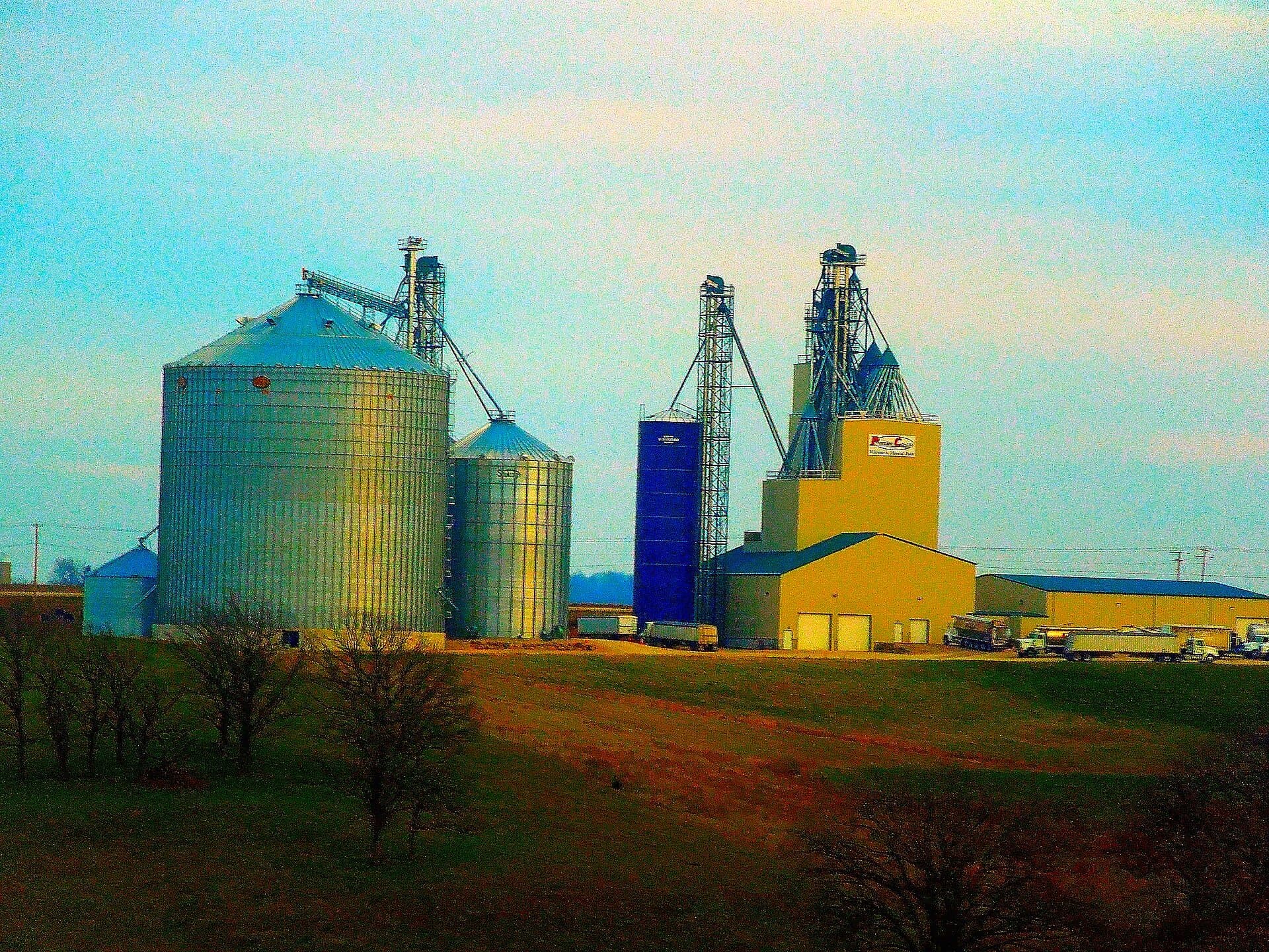 A row of tall concrete grain silos at a Premier Cooperative grain elevator on the American plains