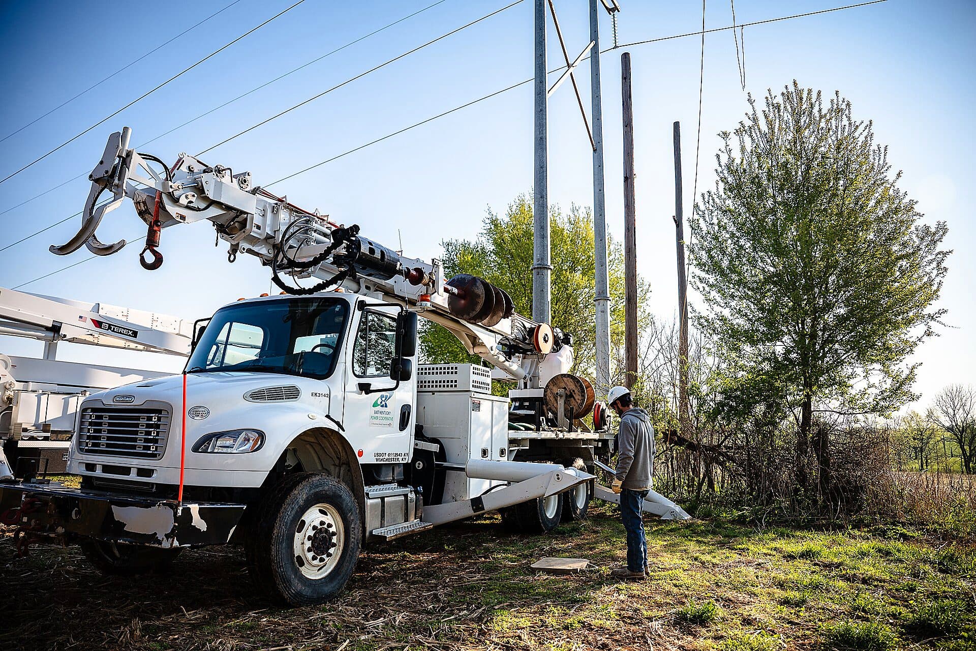 A lineman and bucket truck servicing rural electric cooperative distribution lines in eastern Kentucky